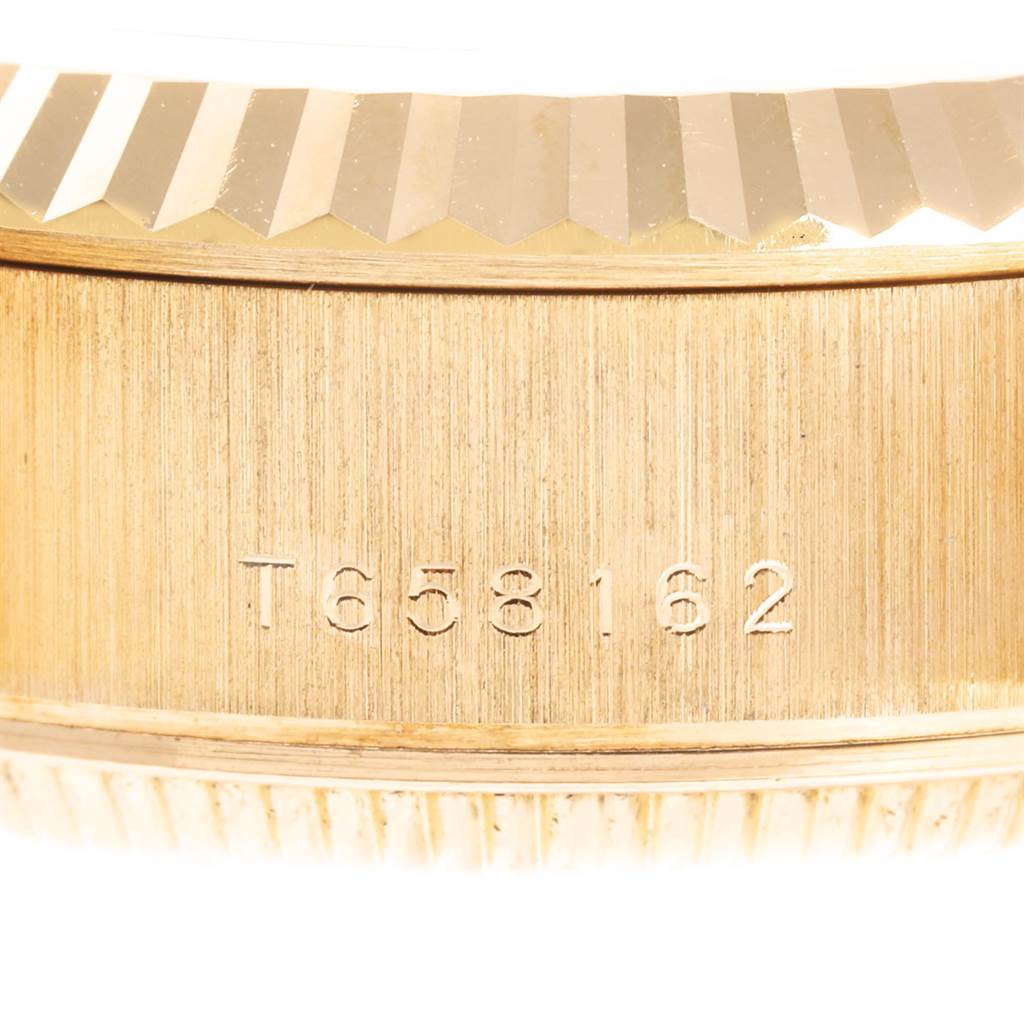 This close-up image shows the side of a Rolex President 69178 Women's Yellow Gold Champagne Dial 69178 Women's Yellow Gold Champagne Dial model watch, highlighting the serial number engraving and fluted bezel.