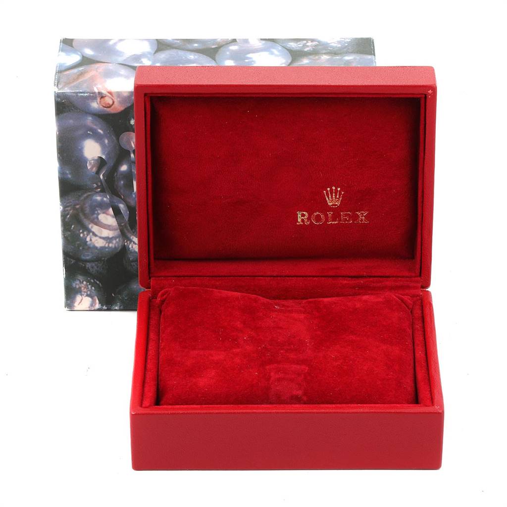 The image shows an open red Rolex box, likely for a President model, displaying its interior velvet lining.