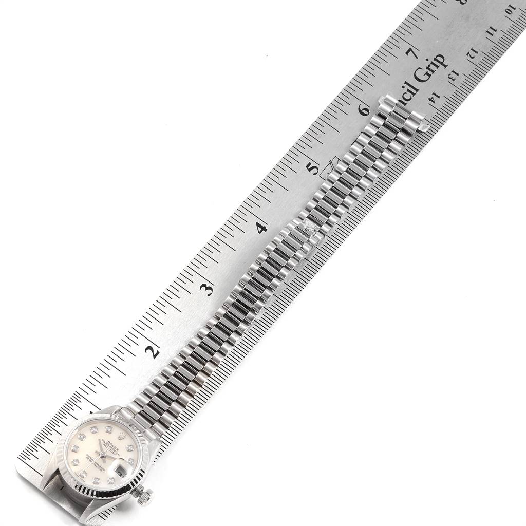 The image shows a Rolex President 69179 Women's White Gold Silver Dial 69179 Women's White Gold Silver Dial model watch laid out flat with a ruler, highlighting the watch face and bracelet.