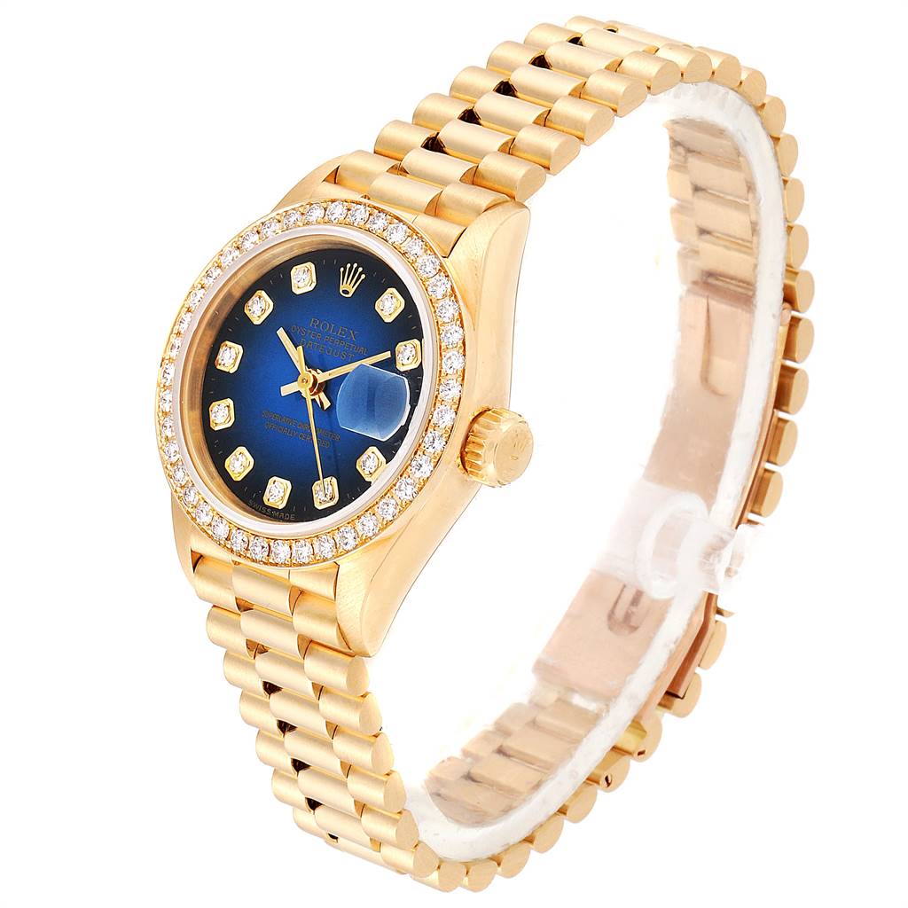 The Rolex President 69138 Women's Yellow Gold Blue Dial 69138 Women's Yellow Gold Blue Dial model watch is shown at an angle highlighting the gold bracelet, blue dial, bezel, and crown.