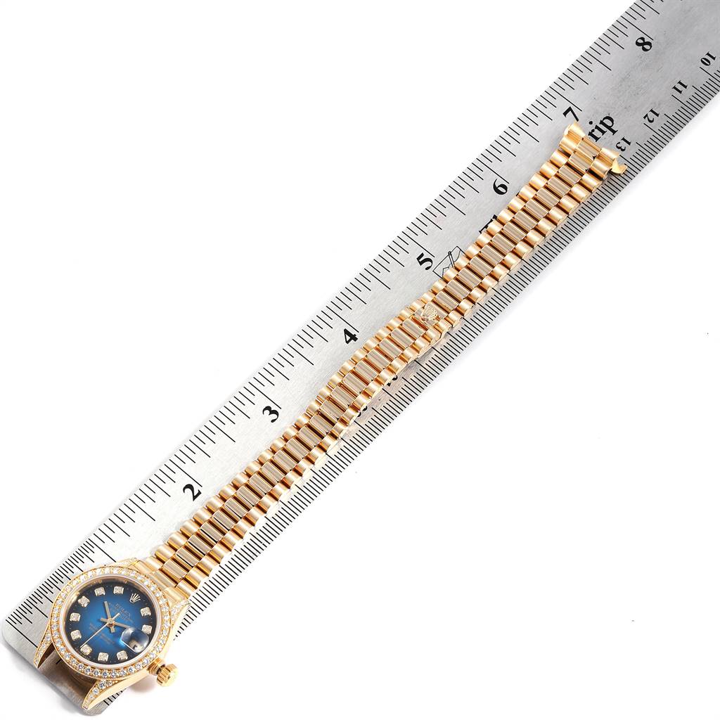 The Rolex President 69158 Women's Yellow Gold Blue Dial 69158 Women's Yellow Gold Blue Dial model watch is shown from a top angle, featuring its face, bezel, and band with a ruler for scale.