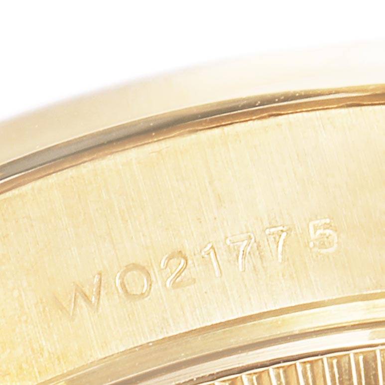 The image shows a close-up of the side of a Rolex President 69158 Women's Yellow Gold Blue Dial 69158 Women's Yellow Gold Blue Dial model watch case with a serial number engraved.