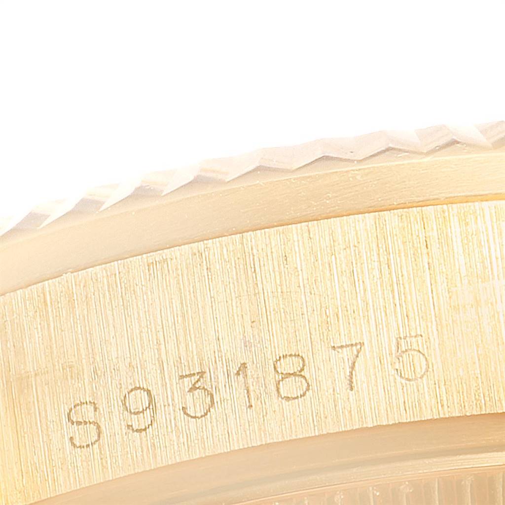 This close-up image of a Rolex President 68278 Women's Yellow Gold White Dial 68278 Women's Yellow Gold White Dial watch shows part of the bezel and case with a visible serial number.