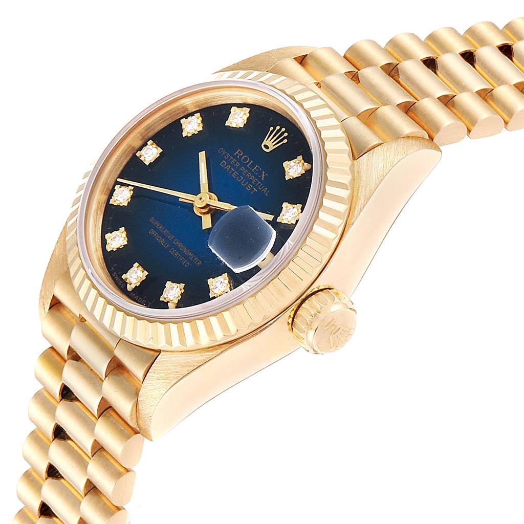 This image shows a Rolex President 69178 Women's Yellow Gold Blue Dial 69178 Women's Yellow Gold Blue Dial model watch at an angle highlighting its gold case, crown, fluted bezel, and part of the bracelet.
