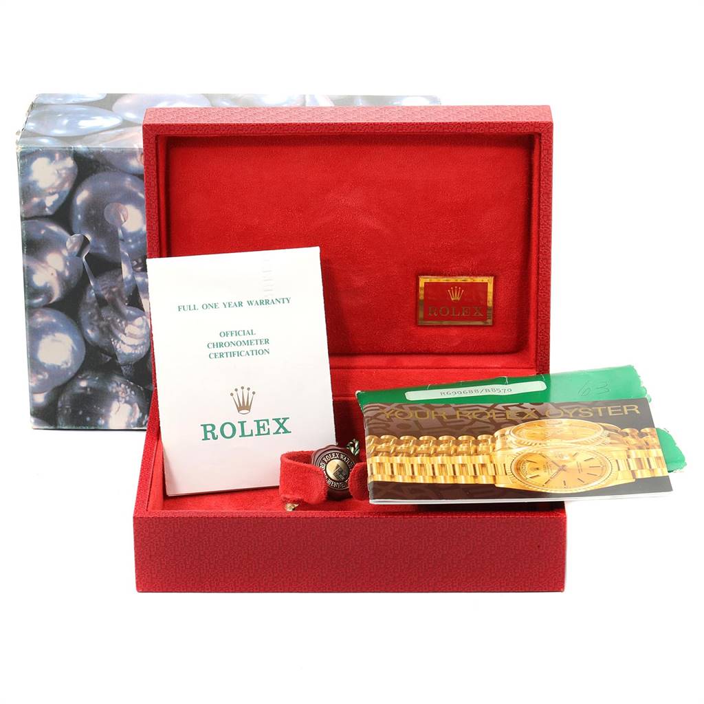 The image shows a Rolex President 69068 Women
s Yellow Gold Mother of Pearl Dial 69068 Women
s Yellow Gold Mother of Pearl Dial model watch box and accessories including a booklet, warranty card, and certification.