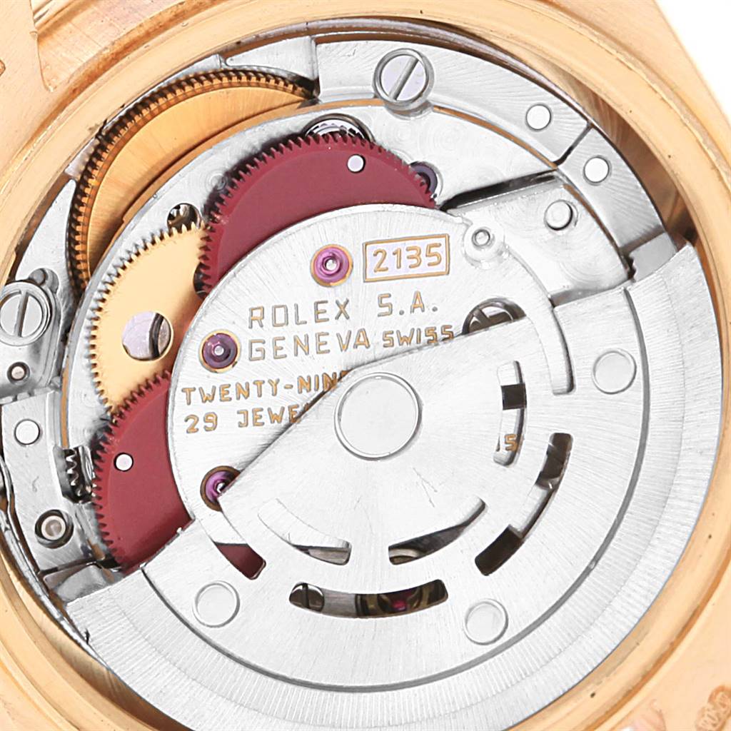 This image shows the intricate movement mechanics of a Rolex President 69138 Yellow Gold Red Dial 69138 Yellow Gold Red Dial model, highlighting the gears and inscriptions.