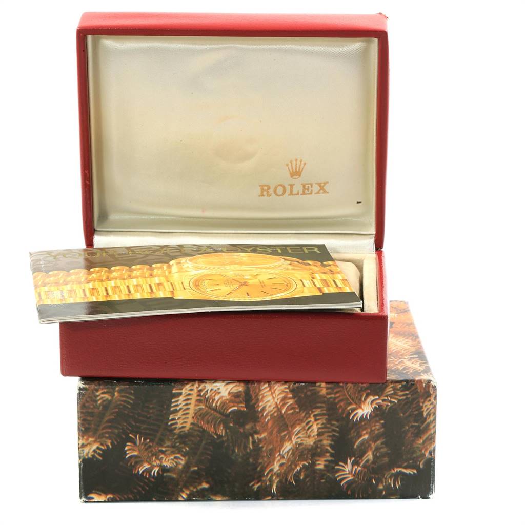The image shows an open Rolex watch box with a booklet for the President model inside.