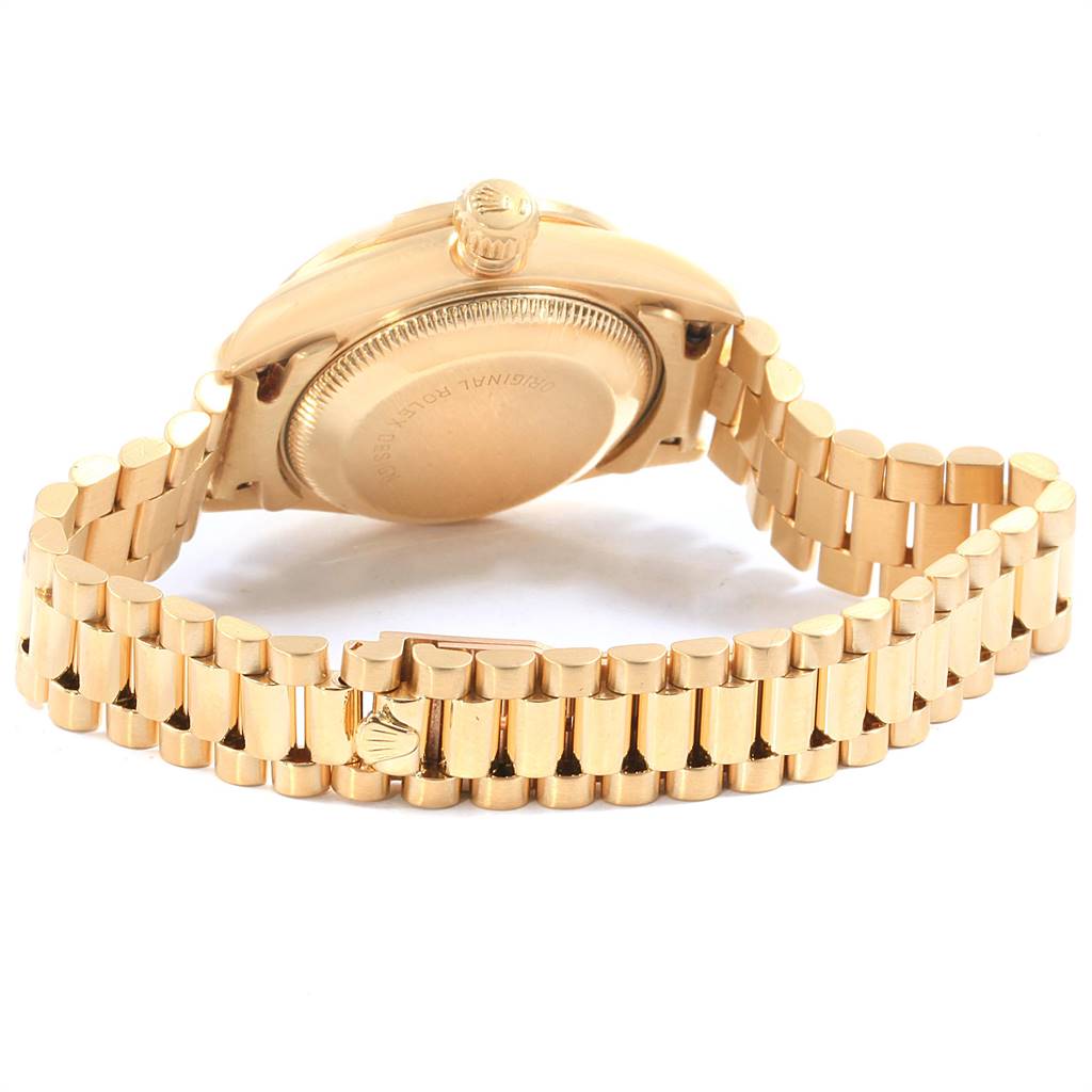 The image shows the back and bracelet of the Rolex President 69138 Yellow Gold Red Dial 69138 Yellow Gold Red Dial model watch, highlighting the clasp and crown.