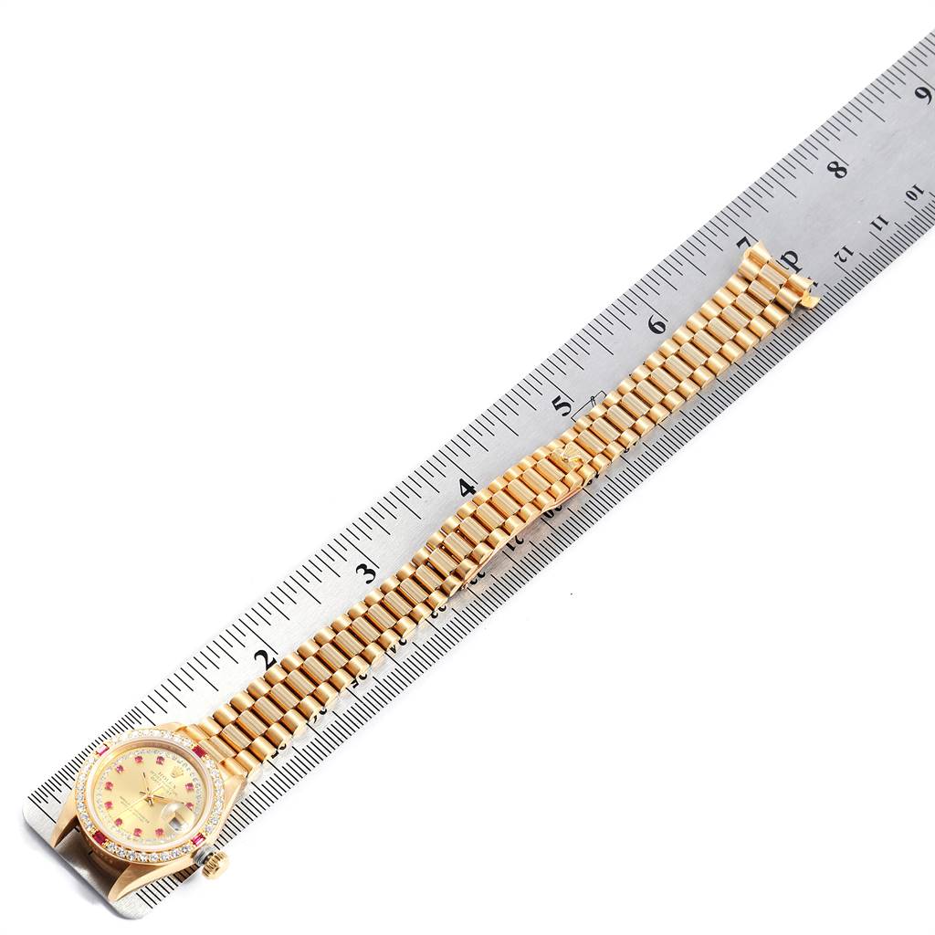 The image shows a Rolex President 69068 Women's Yellow Gold Champagne Dial 69068 Women's Yellow Gold Champagne Dial model watch laid flat next to a ruler, highlighting the watch face and the entire length of the gold bracelet.