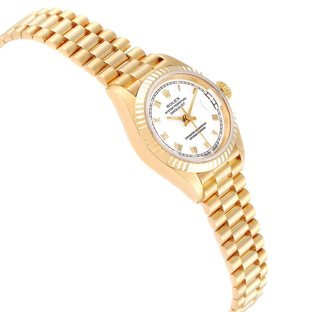 The image shows a Rolex President 69178 Women's Yellow Gold White Dial 69178 Women's Yellow Gold White Dial model watch at an angle highlighting the gold band, white dial, and fluted bezel.