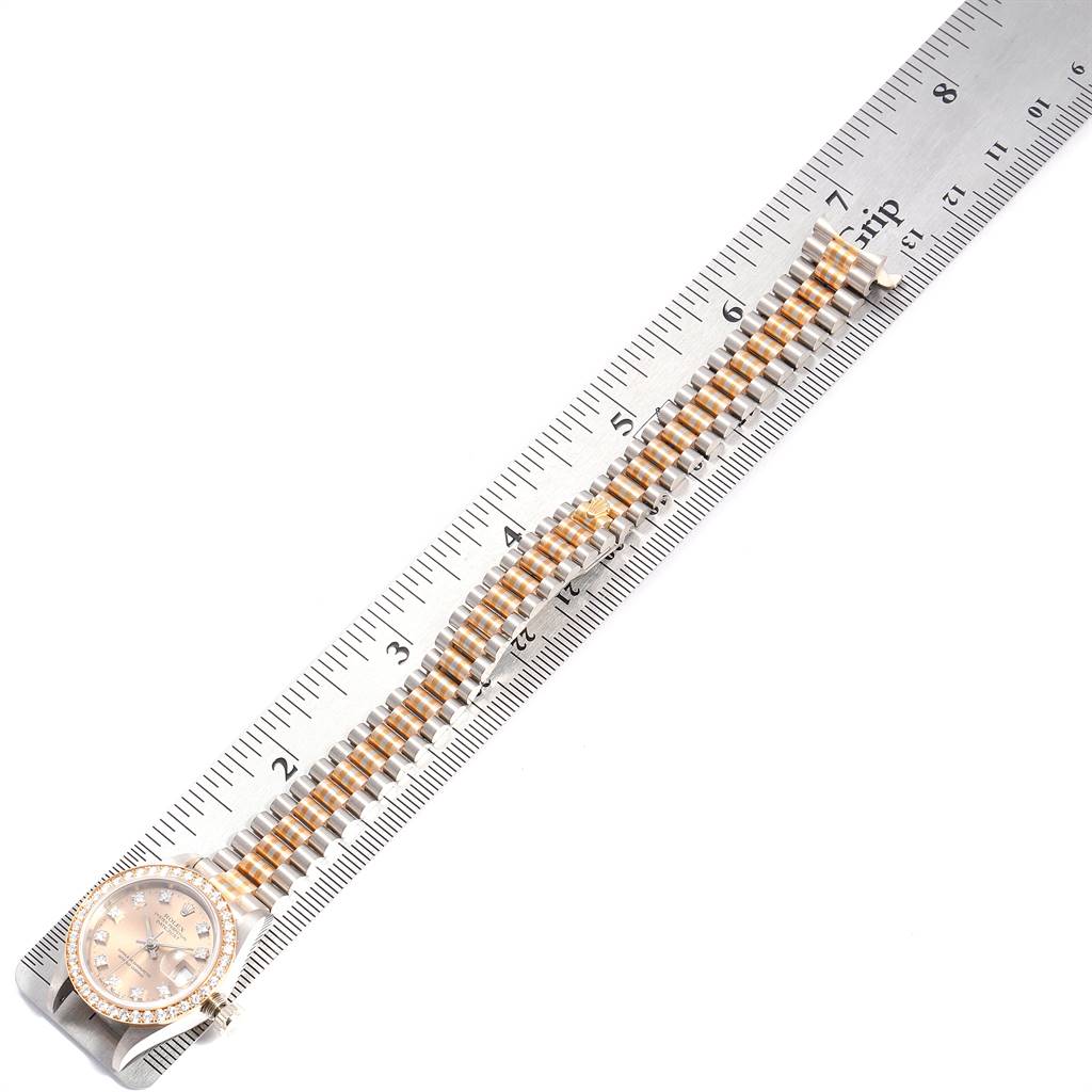 The Rolex President 69179 Women's White Gold Brown Dial 69179 Women's White Gold Brown Dial model watch is shown laid flat on a ruler, displaying the face and two-tone bracelet.