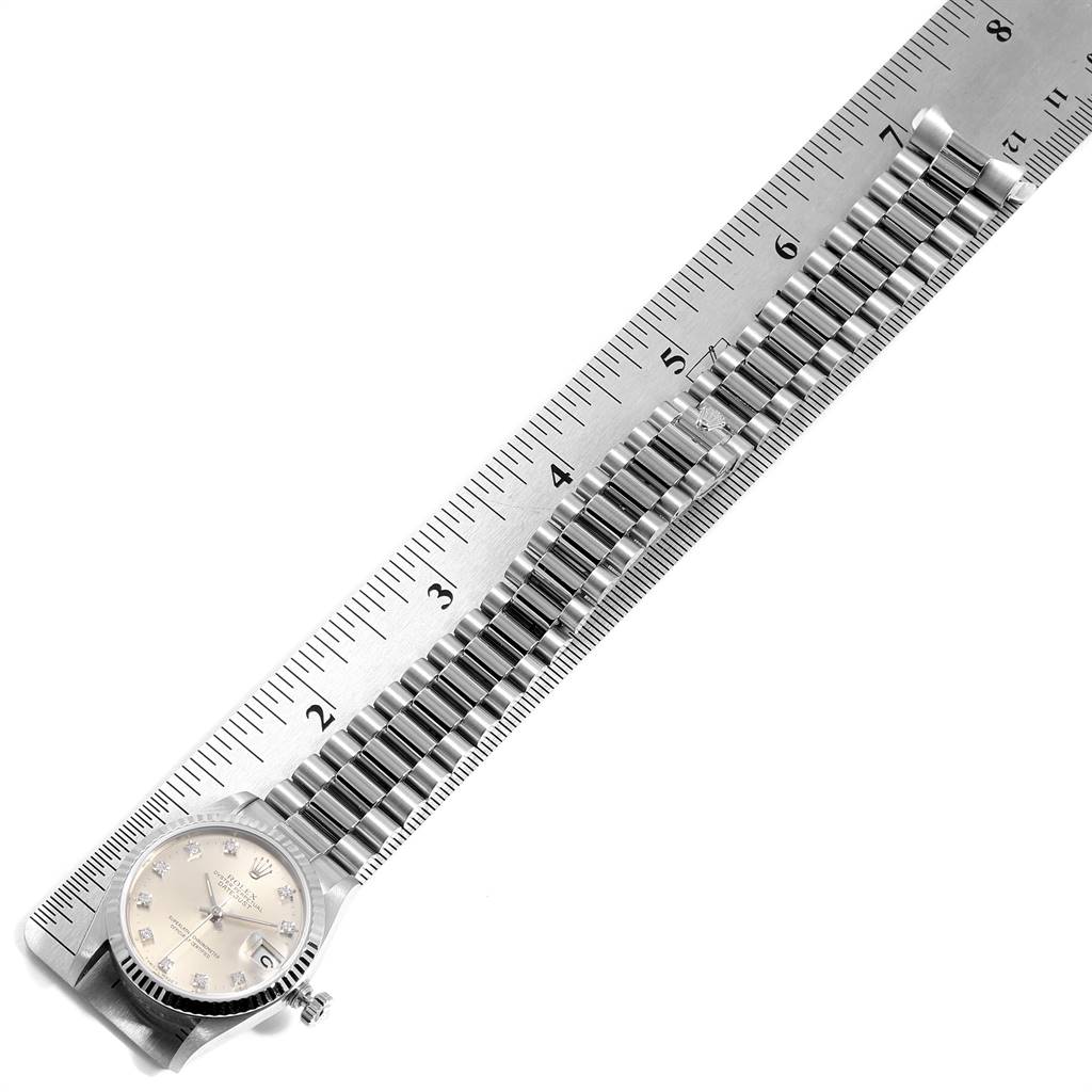 The image shows a Rolex President 68279 Women's White Gold Silver Dial 68279 Women's White Gold Silver Dial model watch laid flat against a ruler, highlighting the watch face and full length of the bracelet.