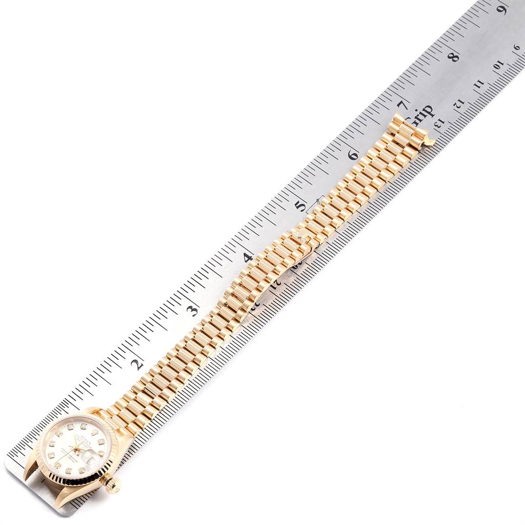 The image shows a Rolex President 69178 Women's Yellow Gold Silver Dial 69178 Women's Yellow Gold Silver Dial model watch and its bracelet, laid next to a ruler for measurement.
