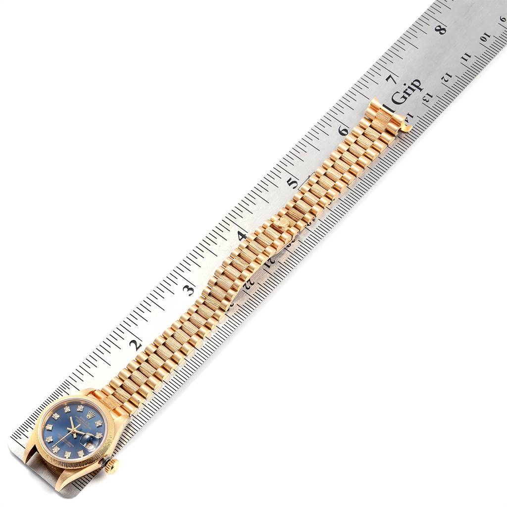 The Rolex President 69278 Women's Yellow Gold Blue Dial 69278 Women's Yellow Gold Blue Dial model watch is displayed fully extended on a ruler, showing the face, band, and clasp.