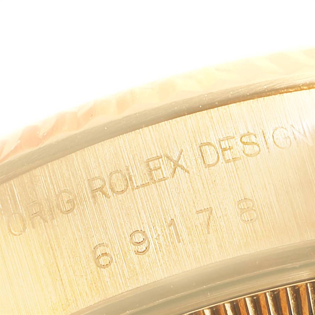 This close-up image shows part of the bezel and engravings on the case side of a Rolex President 69178 Women
s Yellow Gold White Dial 69178 Women
s Yellow Gold White Dial watch.