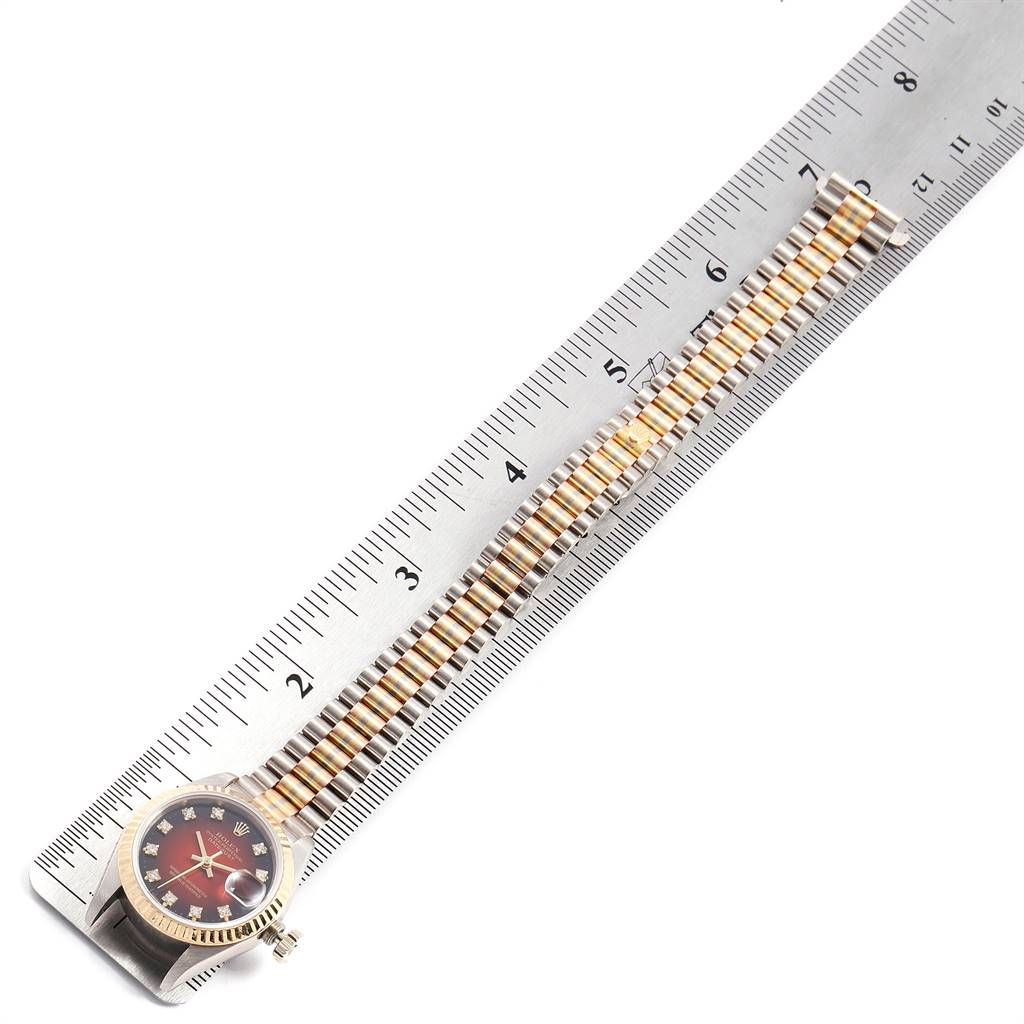 The image shows the side view of a Rolex President 69179 Women's White Gold Red Dial 69179 Women's White Gold Red Dial model watch along with its band measured against a ruler.