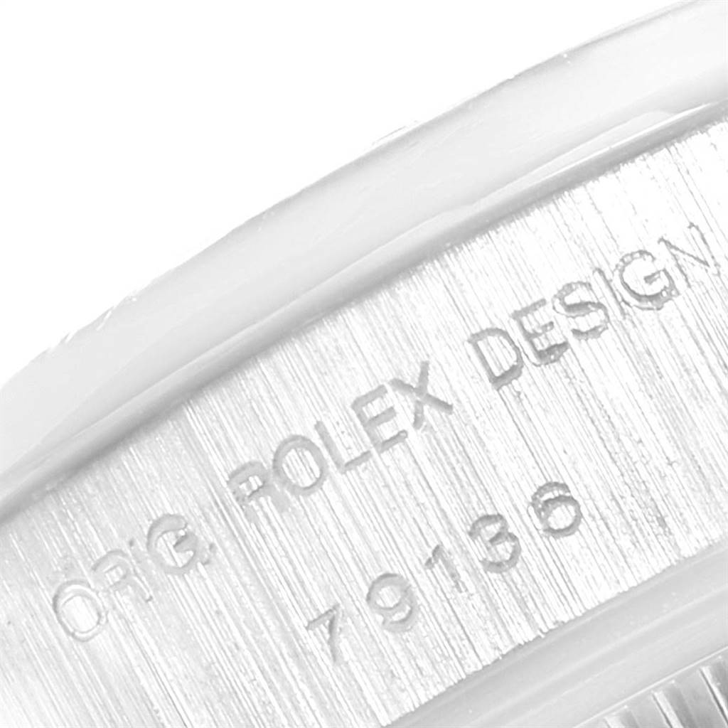 This image shows a close-up of the inner bezel of the Rolex President 79136 Women's Platinum Mother of Pearl Dial 79136 Women's Platinum Mother of Pearl Dial model with "ORIG ROLEX DESIGN" and the serial number engraved.