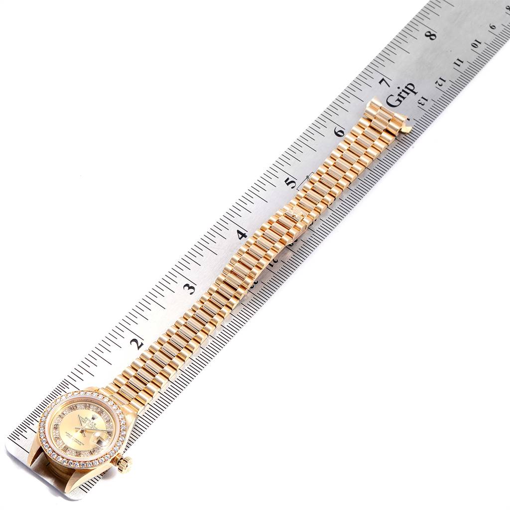 The image shows a Rolex President 69178 Women
s Yellow Gold Champagne Dial 69178 Women
s Yellow Gold Champagne Dial model watch, displaying its face and entire bracelet with a ruler for scale.