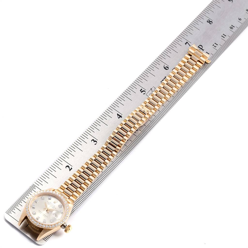 The image shows a Rolex President 69138 Women's Yellow Gold Silver Dial 69138 Women's Yellow Gold Silver Dial model watch laid flat with a metal ruler measuring the length of its bracelet.