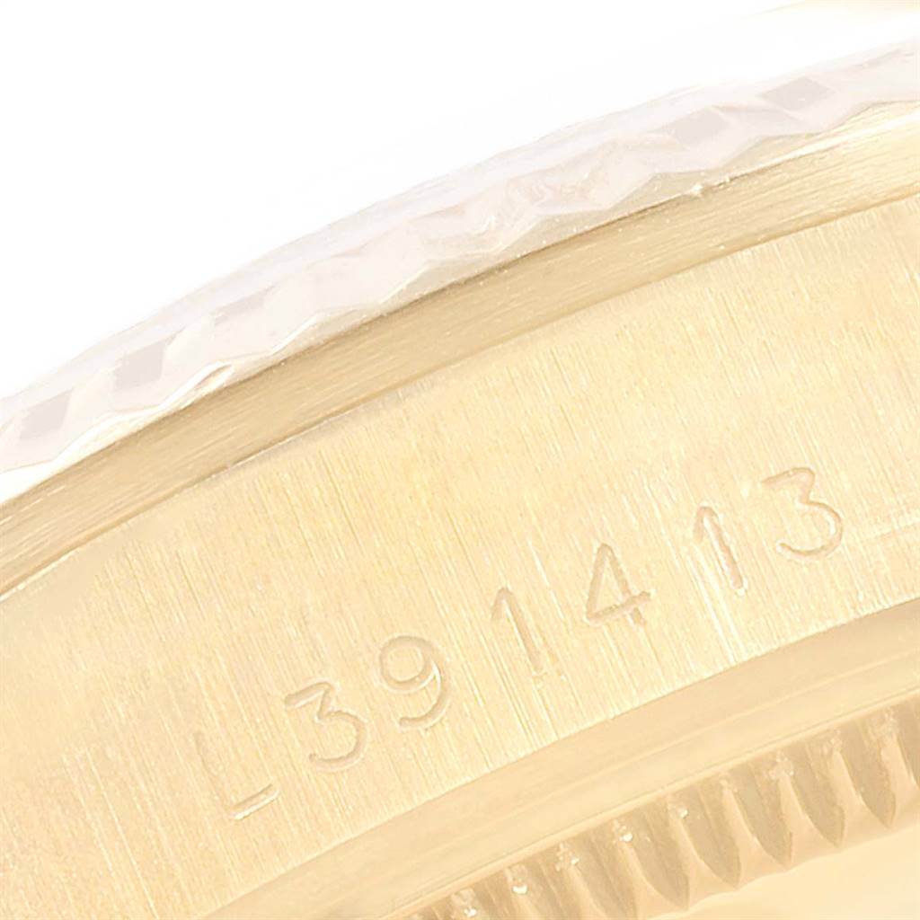 This close-up image shows the edge of a Rolex President 68278 Women
s Yellow Gold Champagne Dial 68278 Women
s Yellow Gold Champagne Dial watch with a focus on its engraved serial number.