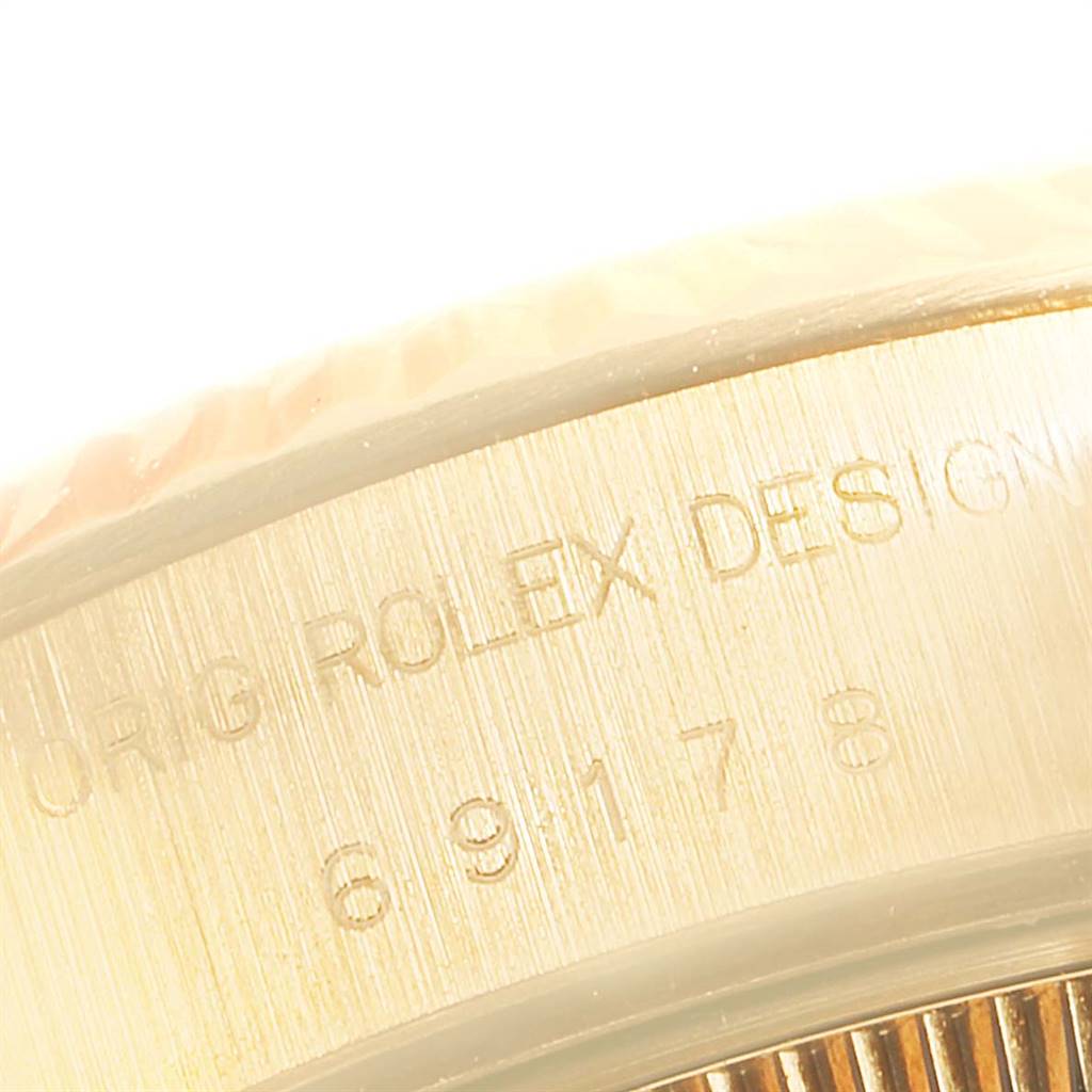 This close-up image shows the engraved side of the bezel on a Rolex President 69178 Women
s Yellow Gold Champagne Dial 69178 Women
s Yellow Gold Champagne Dial watch.