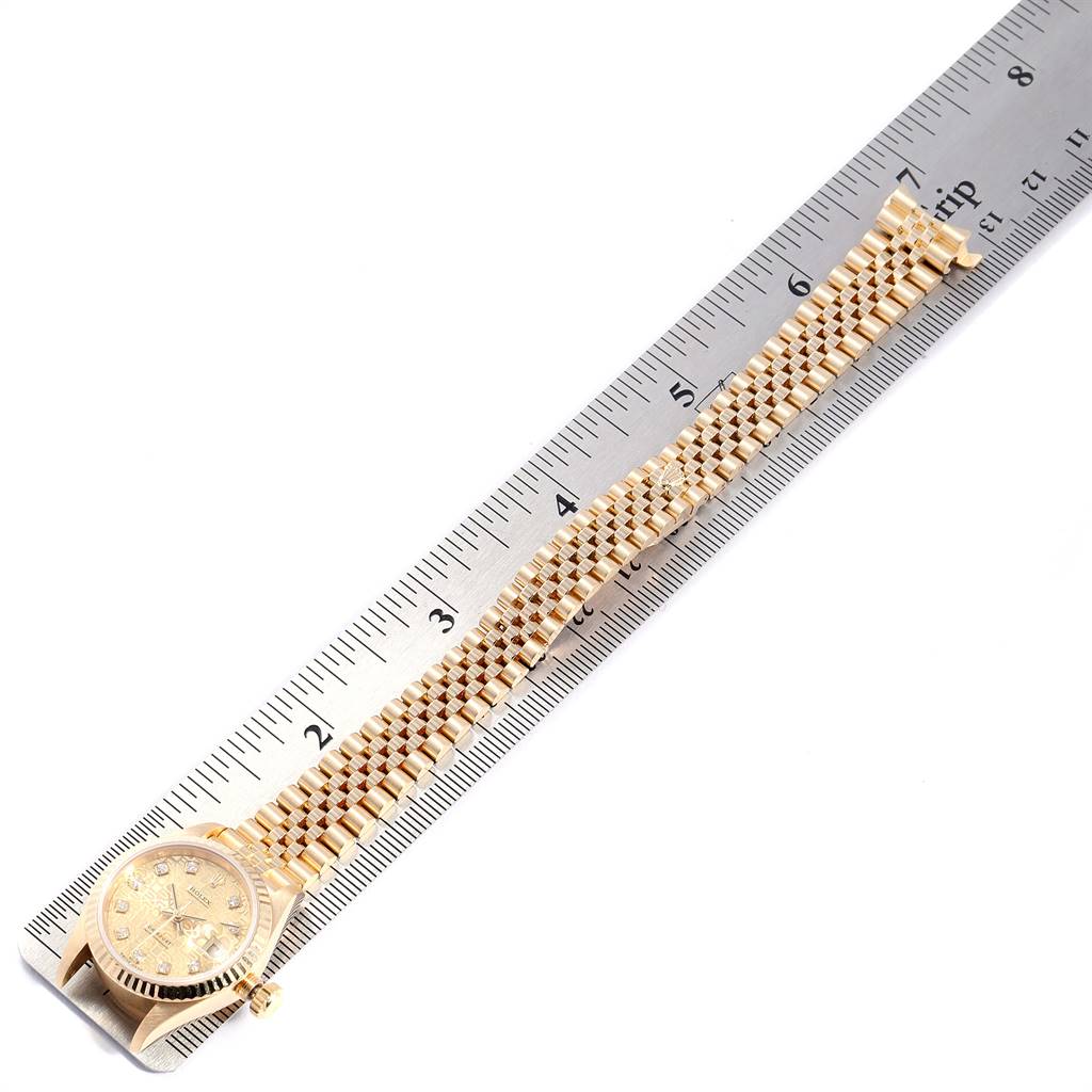 The Rolex President 69178 Women
s Yellow Gold Champagne Dial 69178 Women
s Yellow Gold Champagne Dial model watch is shown from a top view with the wristband aligned next to a ruler.