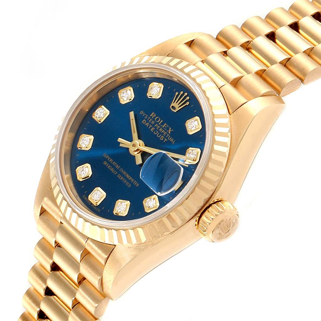This image shows a Rolex President 69178 Women's Yellow Gold Blue Dial 69178 Women's Yellow Gold Blue Dial model watch at an angle displaying its blue dial, diamond hour markers, fluted bezel, and gold bracelet.