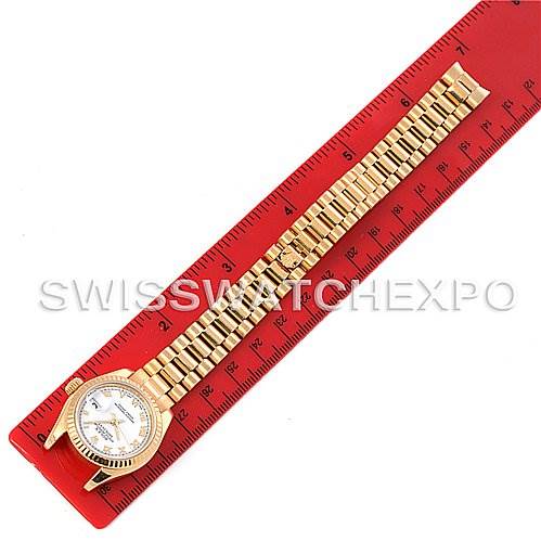 This image shows a top view of the Rolex President 179178 Women's Yellow Gold White Dial 179178 Women's Yellow Gold White Dial model watch, including its dial and bracelet, placed next to a red ruler.