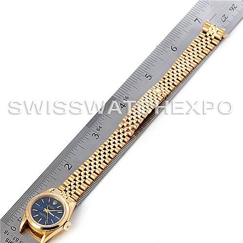 The image shows a Rolex President 67188 Women
s Yellow Gold Blue Dial 67188 Women
s Yellow Gold Blue Dial model watch laid flat beside a ruler, displaying the watch face, bezel, and full bracelet.