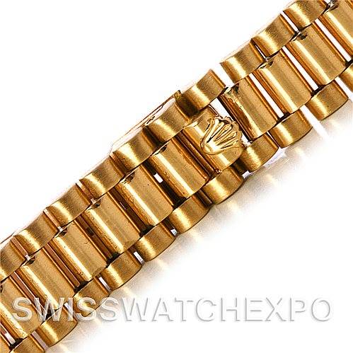 The image shows a close-up of the gold bracelet of a Rolex President 69178 Women's Yellow Gold Black Dial 69178 Women's Yellow Gold Black Dial model watch, featuring the Rolex crown logo.