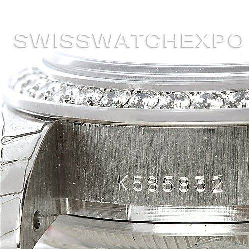 This close-up image of the Cartier Tank Française watch shows the side, part of the metal bracelet, serial number, and diamond bezel.