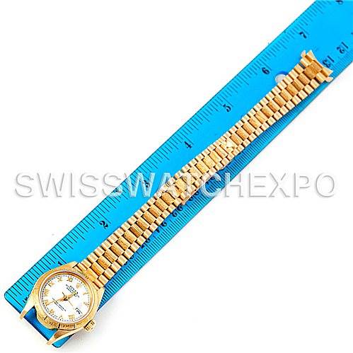 This top-down view shows the entire Rolex President 69278 Women's Yellow Gold White Dial 69278 Women's Yellow Gold White Dial watch, including its face, case, and bracelet, laid next to a ruler.