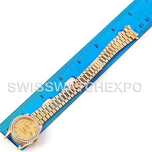 The image shows a Rolex President 69138 Women's Yellow Gold Champagne Dial 69138 Women's Yellow Gold Champagne Dial model watch laid flat next to a blue ruler, displaying the full length of the band and face.