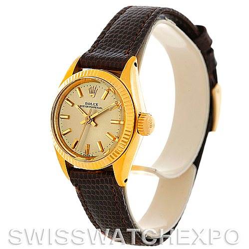 The image shows a Rolex President 6719 Women
s Yellow Gold Champagne Dial 6719 Women
s Yellow Gold Champagne Dial model watch at an angled side view, highlighting the face, bezel, crown, and leather strap.