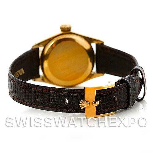 This image shows the back view of a Rolex President 6719 Women
s Yellow Gold Champagne Dial 6719 Women
s Yellow Gold Champagne Dial watch with a gold case and a dark brown leather strap.