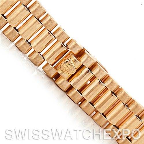 This image shows a close-up of the President bracelet of a Rolex watch, highlighting its links and the Rolex crown clasp.