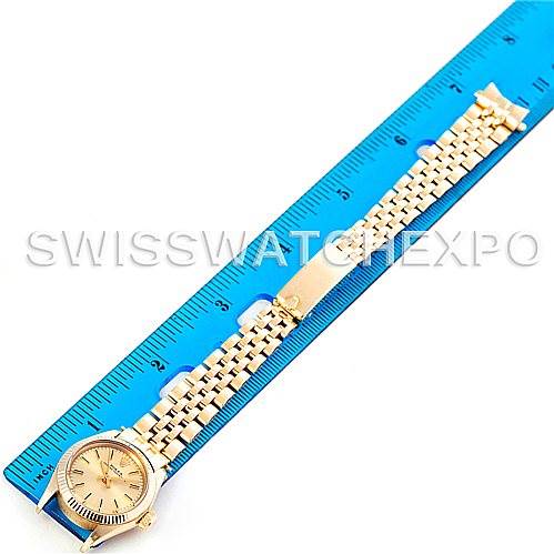 The image shows a Rolex President 6719 Women's Yellow Gold Champagne Dial 6719 Women's Yellow Gold Champagne Dial watch laid flat next to a blue ruler, displaying the face, band, and clasp from a top view.