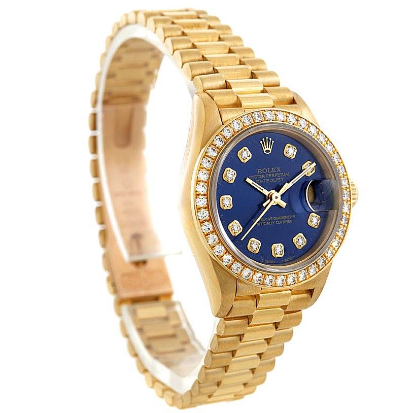 This photo shows a side view of the Rolex President 69138 Women's Yellow Gold Blue Dial 69138 Women's Yellow Gold Blue Dial watch, displaying its gold bracelet, diamond bezel, and blue dial.