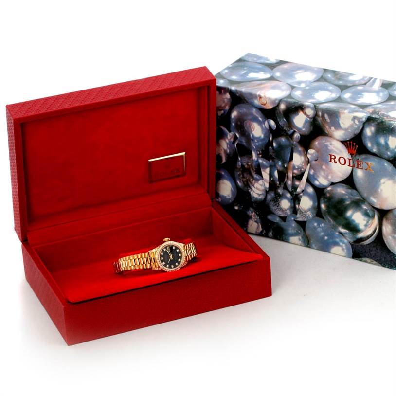 The Rolex President 69158 Women's Yellow Gold Black Dial 69158 Women's Yellow Gold Black Dial model watch is shown inside an open red box, alongside another decorative Rolex box.