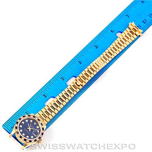The Rolex President 69198 Women's Yellow Gold Blue Dial 69198 Women's Yellow Gold Blue Dial model watch is shown laid flat next to a ruler, displaying the dial, bezel, case, and bracelet.