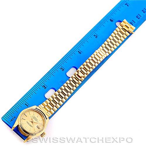 The image shows a Rolex President 6917 Women's Yellow Gold Champagne Dial 6917 Women's Yellow Gold Champagne Dial model watch placed next to a blue ruler for scale, displaying the face and full bracelet.