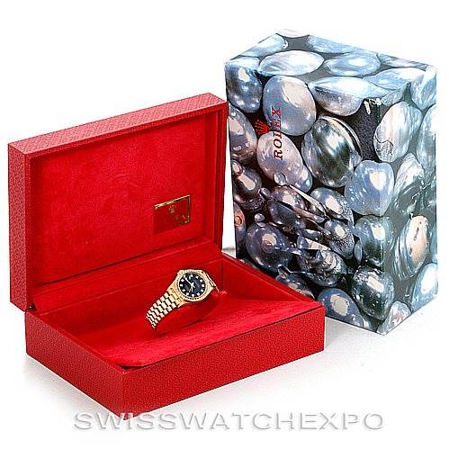 The image shows a Rolex President 69178 Women's Yellow Gold Black Dial 69178 Women's Yellow Gold Black Dial model watch in its red open box, alongside the decorative outer packaging.