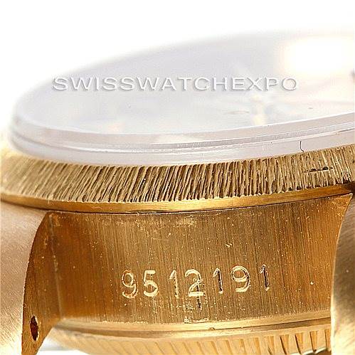 This image shows a close-up of the Rolex President 69278 Women's Yellow Gold Champagne Dial 69278 Women's Yellow Gold Champagne Dial watch, specifically the serial number and part of the gold case and bezel.