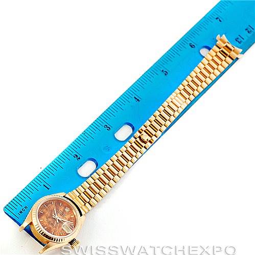 The Rolex President 69178 Women's Yellow Gold Brown Dial 69178 Women's Yellow Gold Brown Dial model watch is shown from a top-down angle, alongside a blue ruler for size reference.