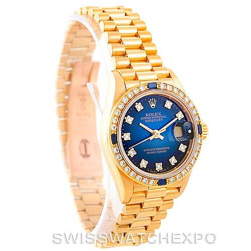 This image shows a side angle of a Rolex President 69088 Women's Yellow Gold Blue Dial 69088 Women's Yellow Gold Blue Dial model watch, highlighting its gold bracelet, blue dial, diamond indices, and bezel.