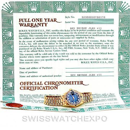 The image shows a Rolex President 69088 Women's Yellow Gold Blue Dial 69088 Women's Yellow Gold Blue Dial model watch placed on top of its warranty and chronometer certification papers.