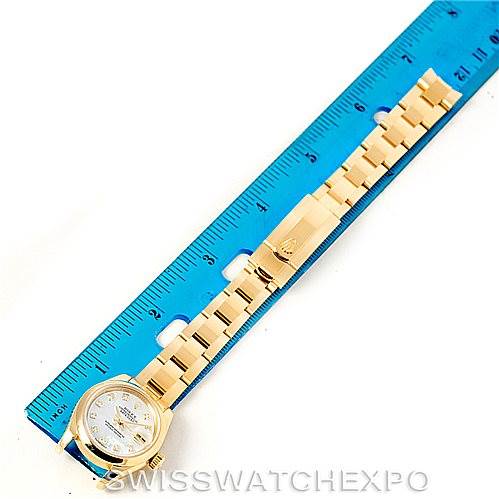The image shows a Rolex President 179168 Women's Yellow Gold Mother of Pearl Dial 179168 Women's Yellow Gold Mother of Pearl Dial model watch laid flat next to a blue ruler, showcasing its band and face.