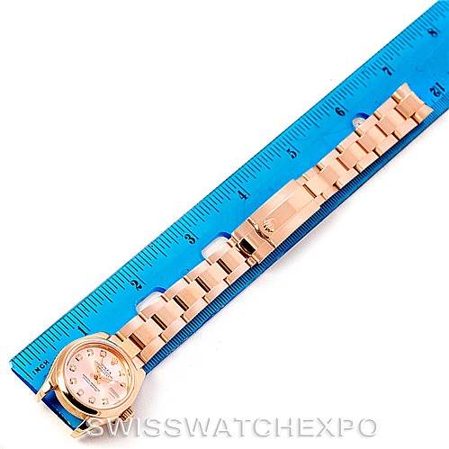 The image shows a Rolex President 179165 Women's Rose Gold Pink Dial 179165 Women's Rose Gold Pink Dial model watch laid flat alongside a blue ruler for scale.