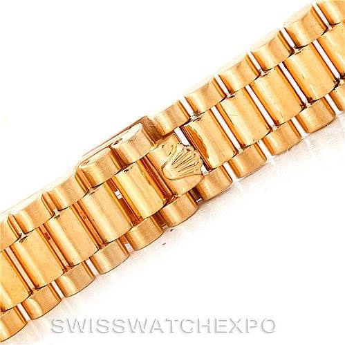 This image shows a close-up of the gold bracelet of a Rolex President 69158 Women's Yellow Gold Champagne Dial 69158 Women's Yellow Gold Champagne Dial model watch, focusing on the crown logo clasp.