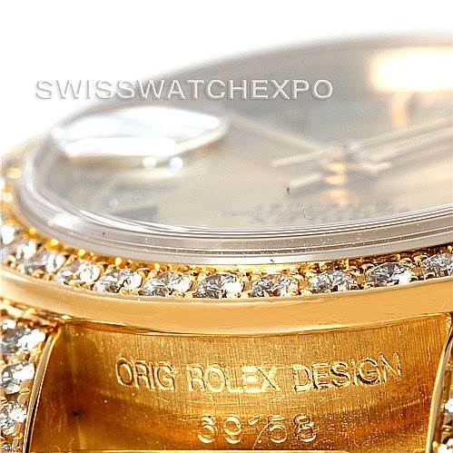 This close-up image of a Rolex President 69158 Women's Yellow Gold Champagne Dial 69158 Women's Yellow Gold Champagne Dial model watch shows the bezel adorned with diamonds and part of the case with engraved details.